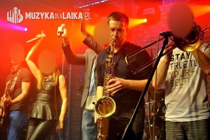 Koncert z zespołem na scenie, saksofon na pierwszym planie