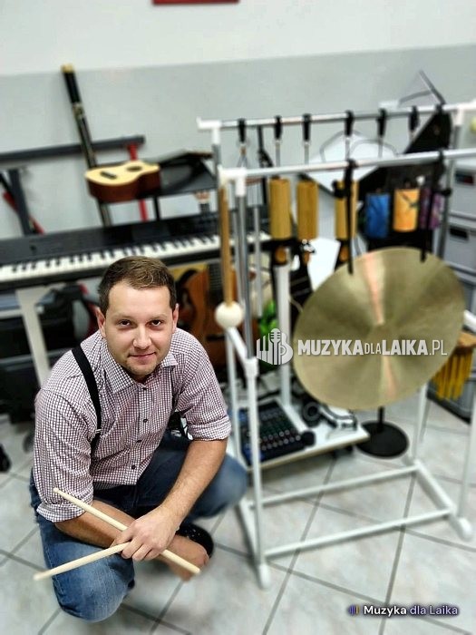 Michał Drezner przy gongu i dzwonkach w sali z instrumentami