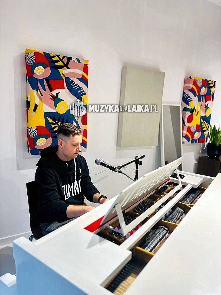 Michał Drezner przy białym fortepianie