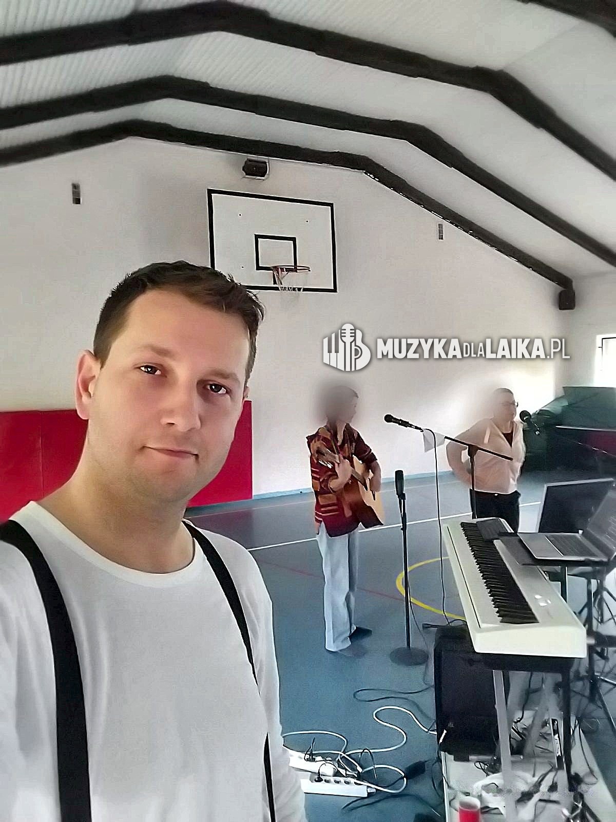 Michał Drezner na hali sportowej podczas przygotowań, twarze dwóch osób z zespołu zasłonięte