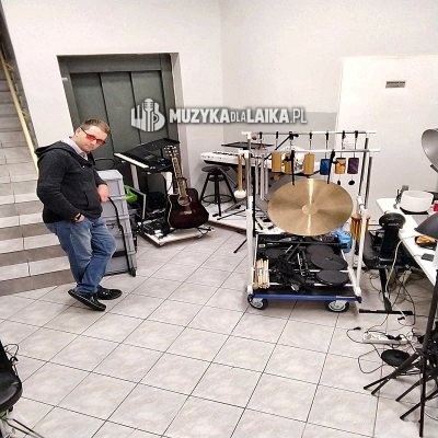 Michał Drezner w sali z instrumentami przygotowanymi na statywach