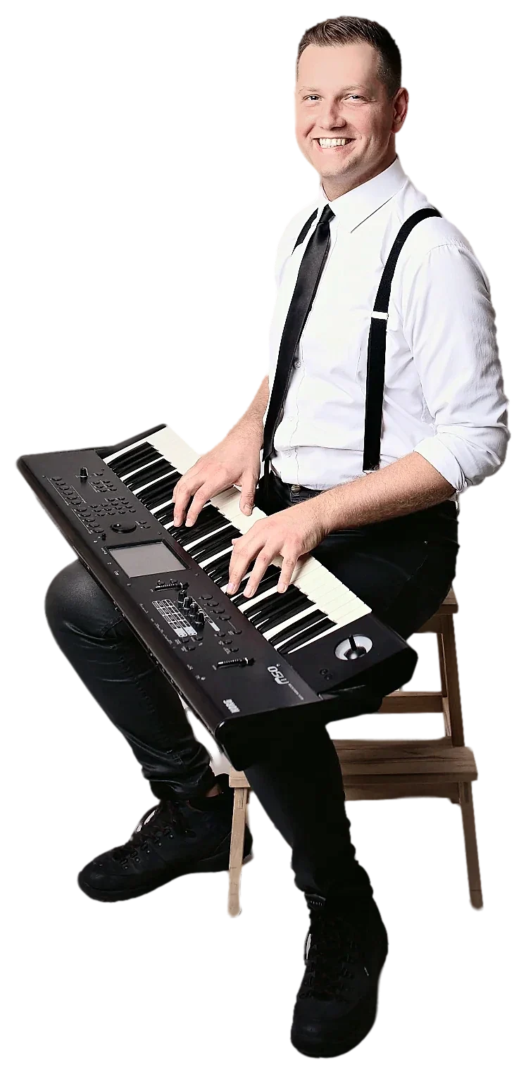 Michał Drezner przy keyboardzie, uśmiechnięty