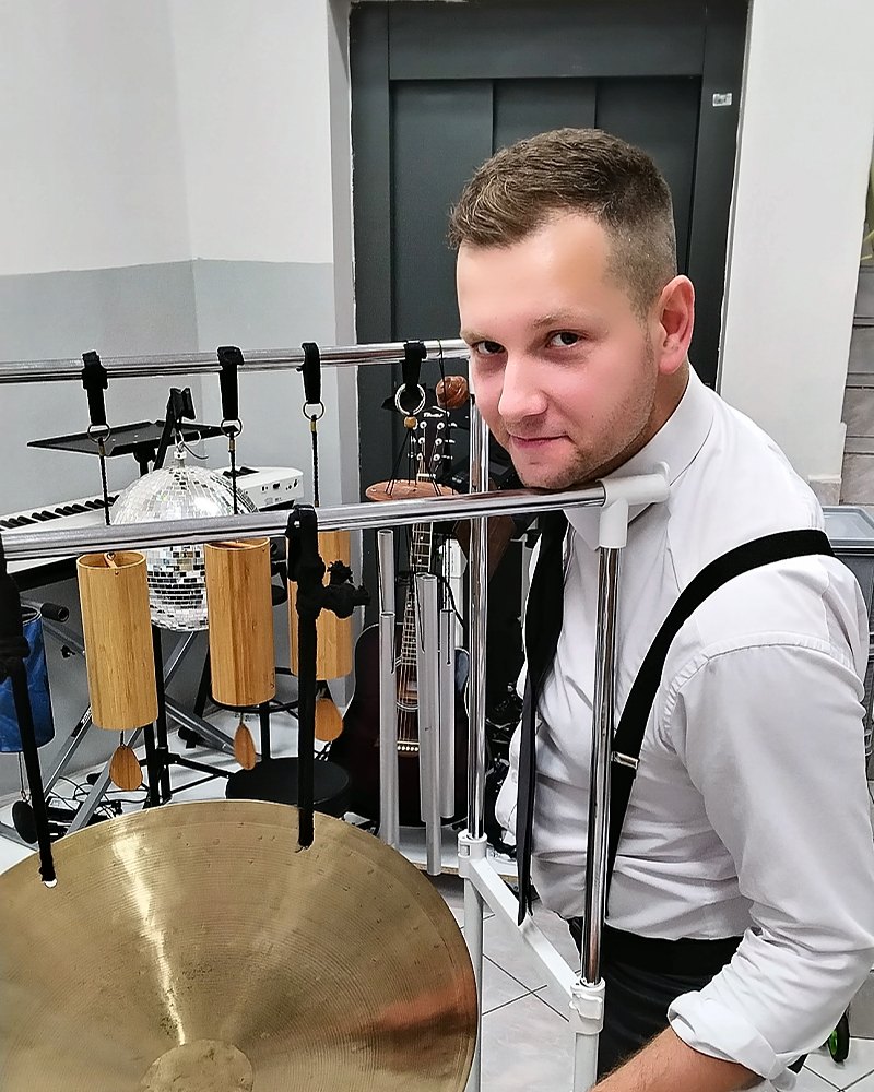 Michał Drezner przy dużym gongu, z pałką w dłoni