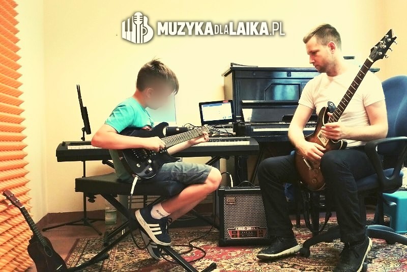 Michał Drezner uczy chłopca gry na gitarze elektrycznej; twarz chłopca zasłonięta.