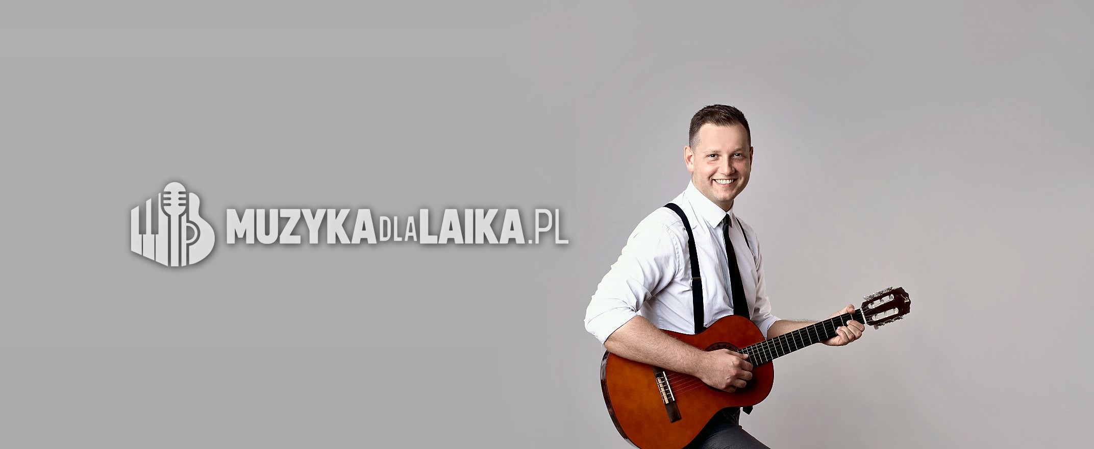 Michał Drezner z gitarą, uśmiechnięty