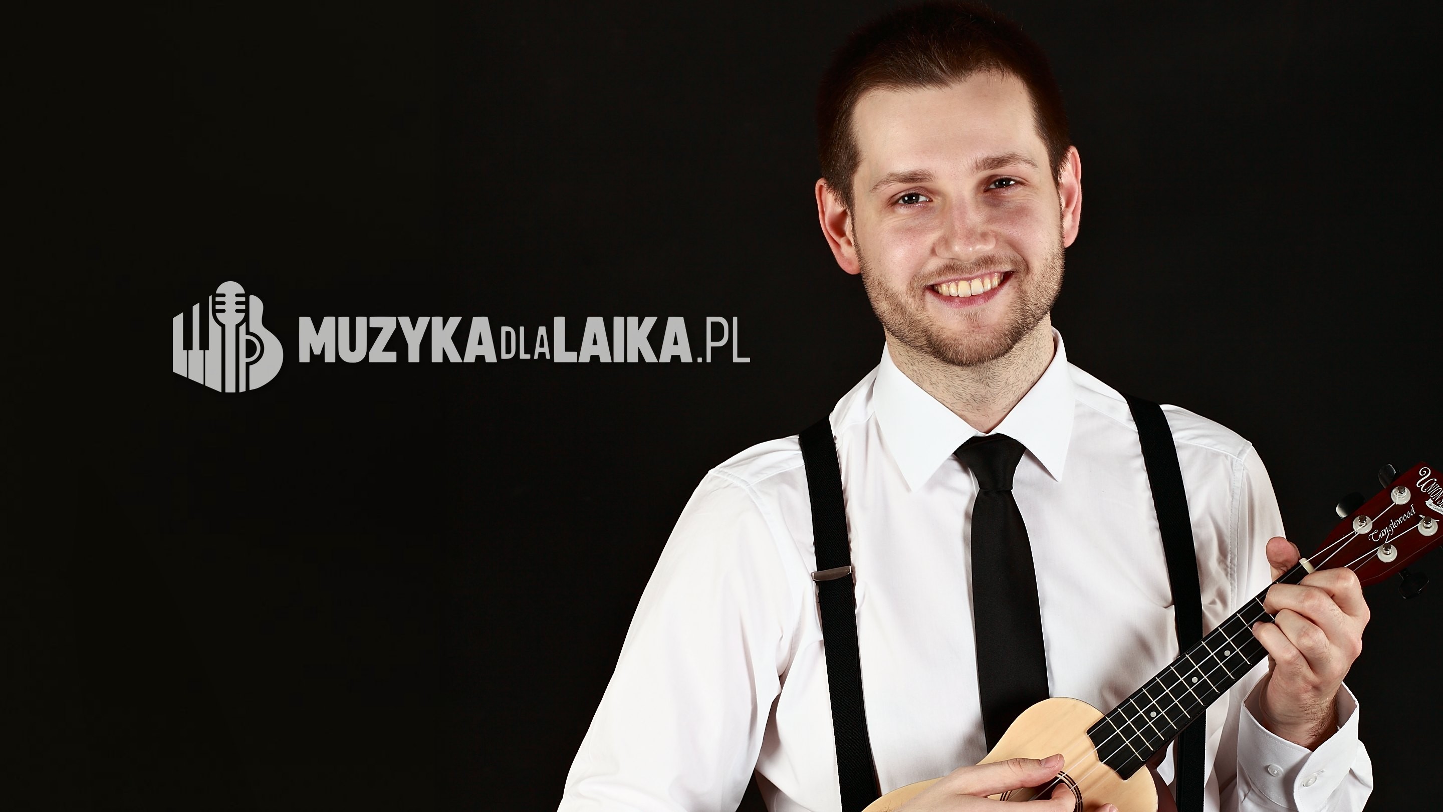 Michał Drezner w białej koszuli gra na ukulele i uśmiecha się